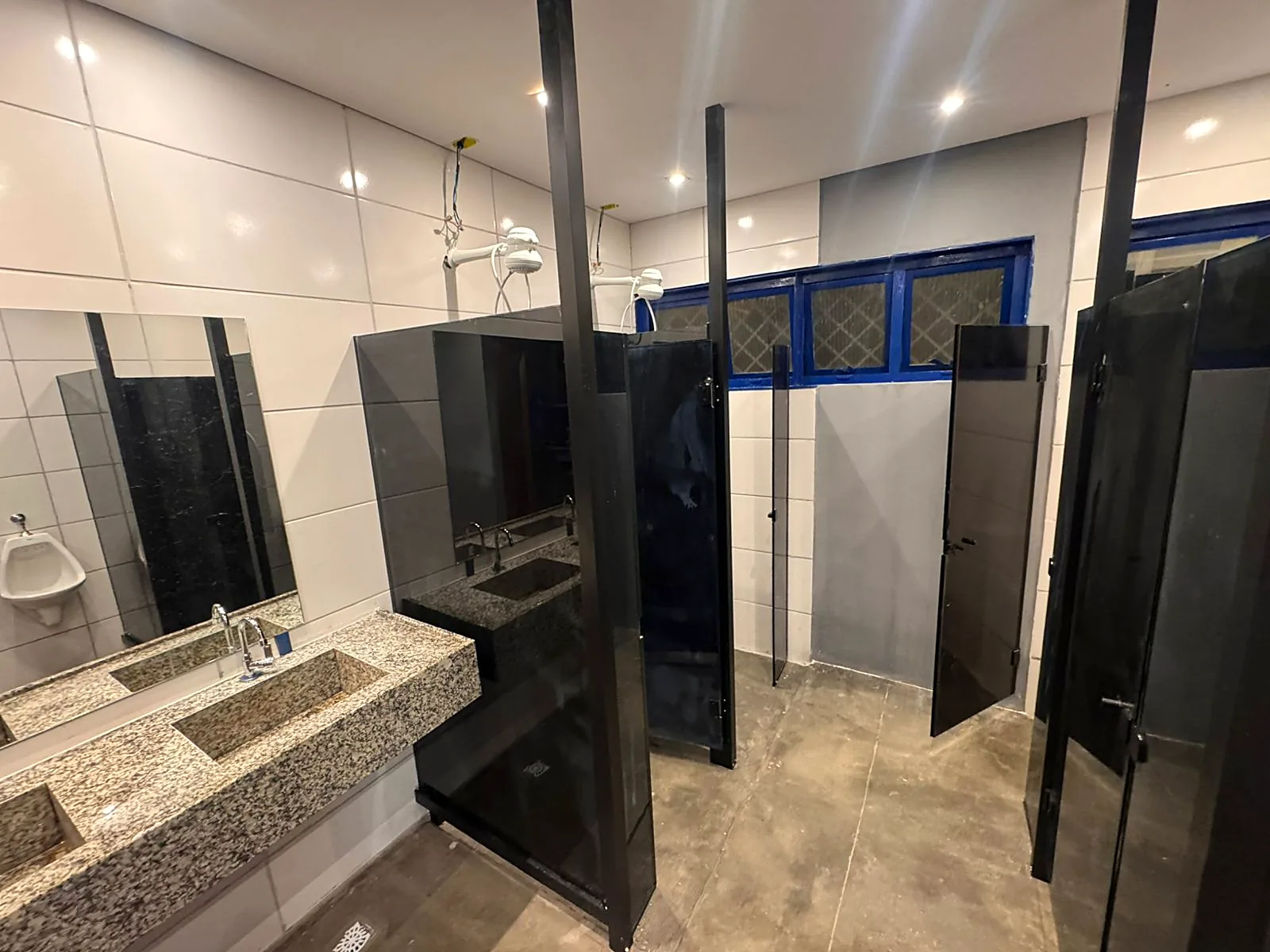 Vestiário entregue com divisórias, bancada em granito e iluminação